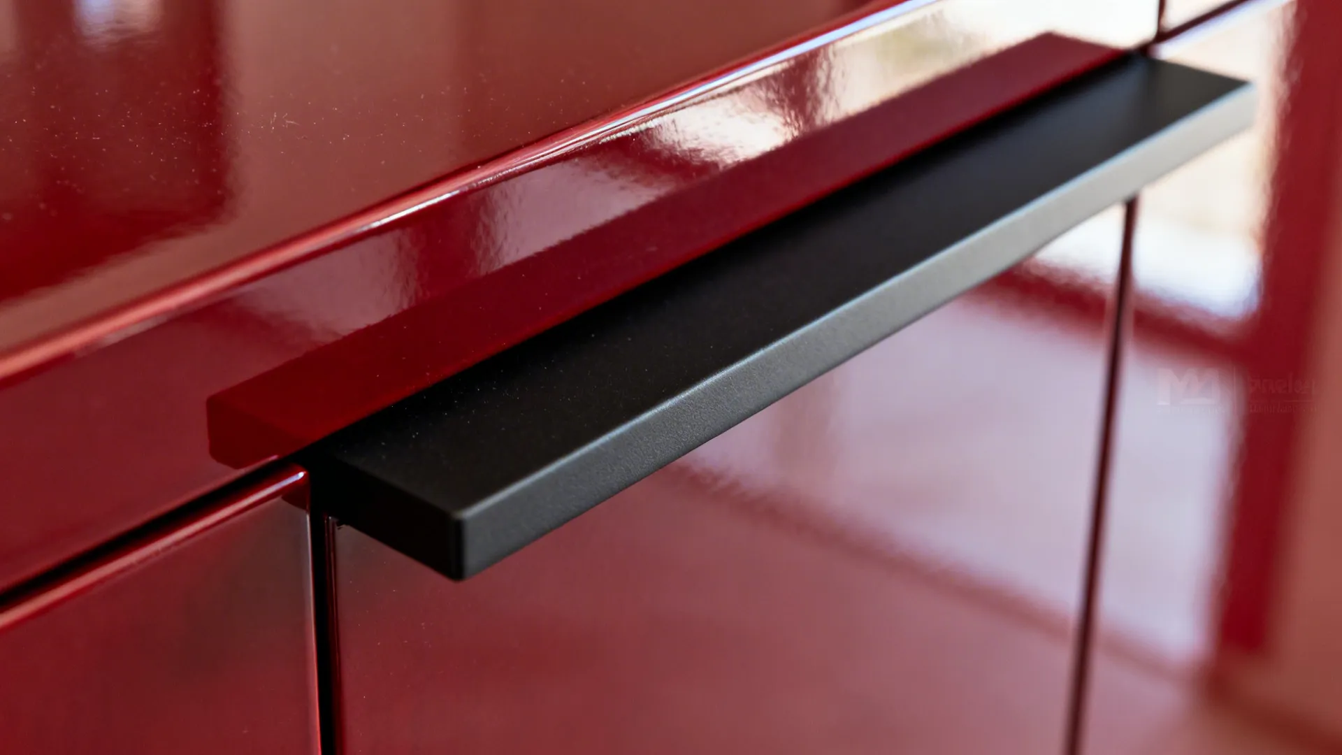 Glossy red cabinetry with matte black hardware