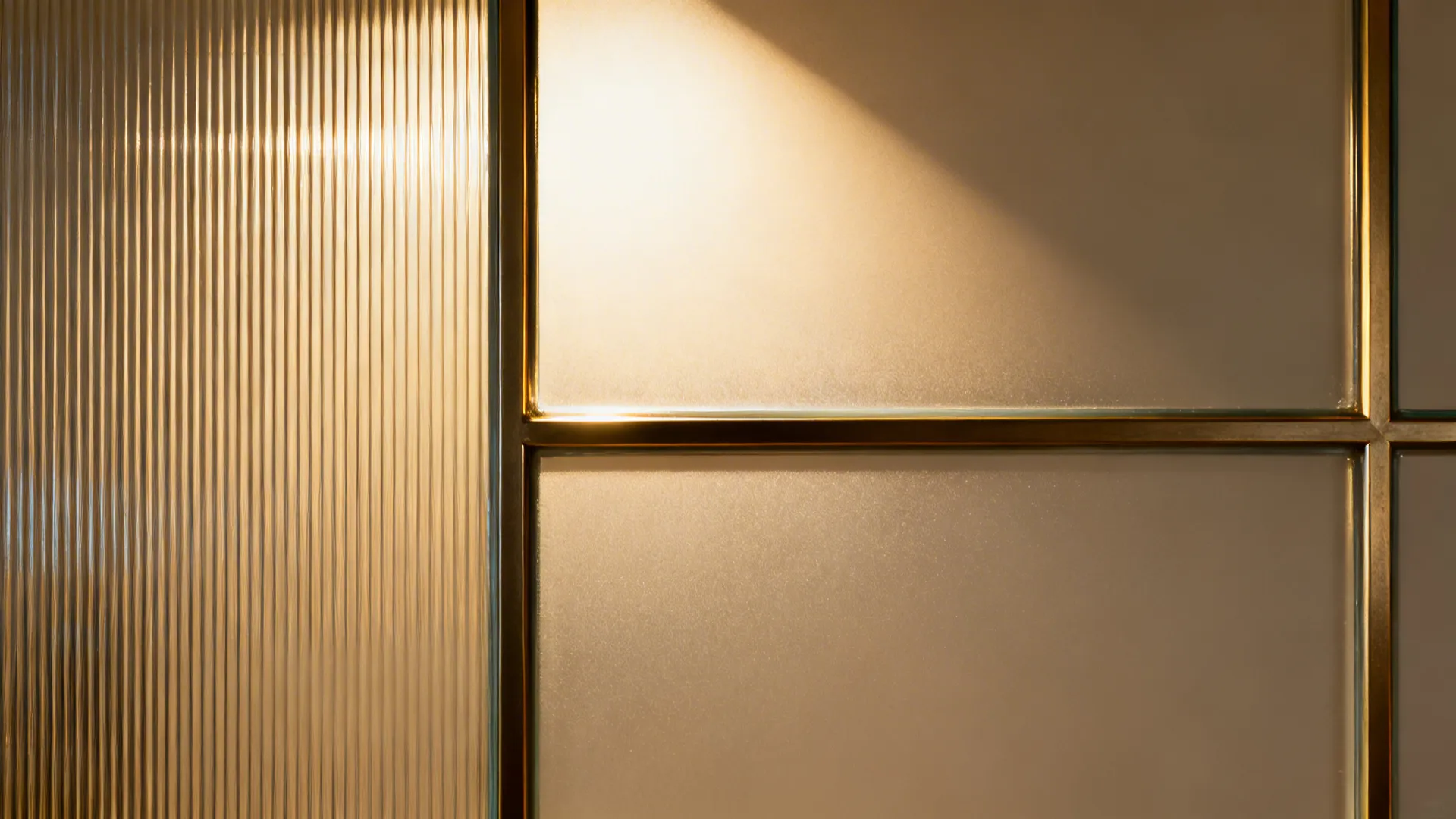 Close-up of reeded and frosted glass panels with slim frame and matte wall behind.