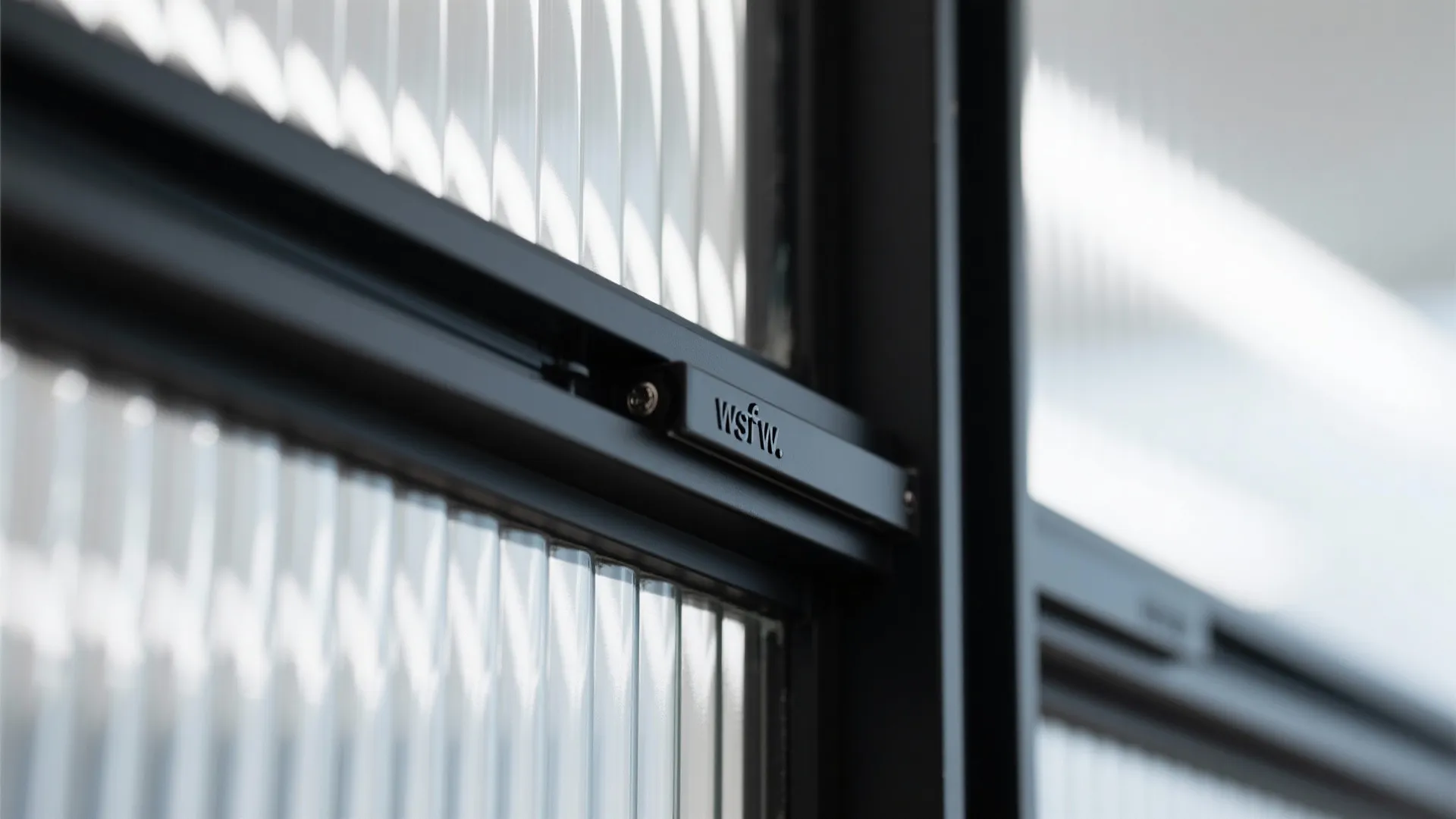 Close up view of textured glass panel with black metal frame and small sliding door