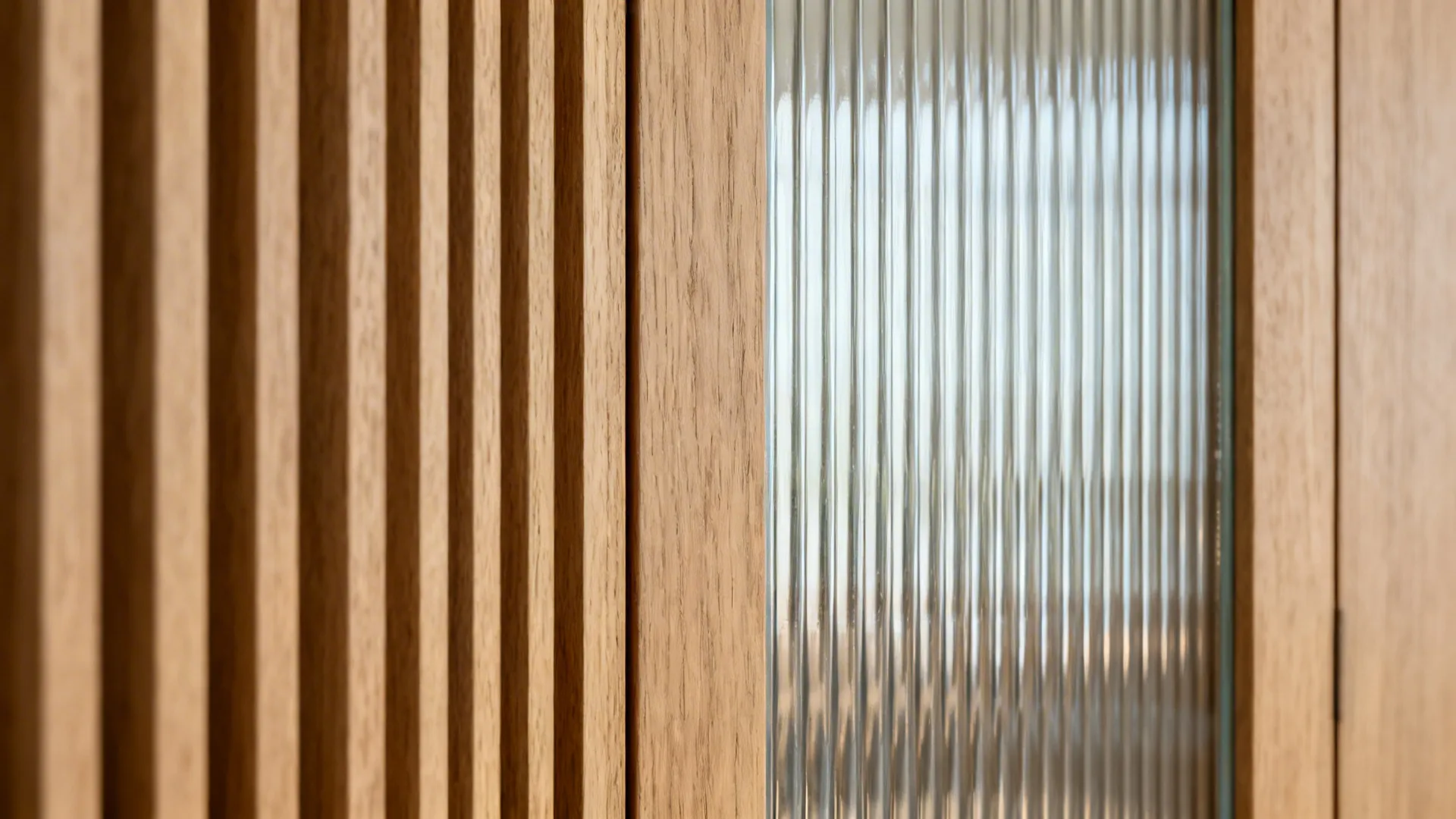 Close up of wooden wall panel next to textured glass window with vertical line design