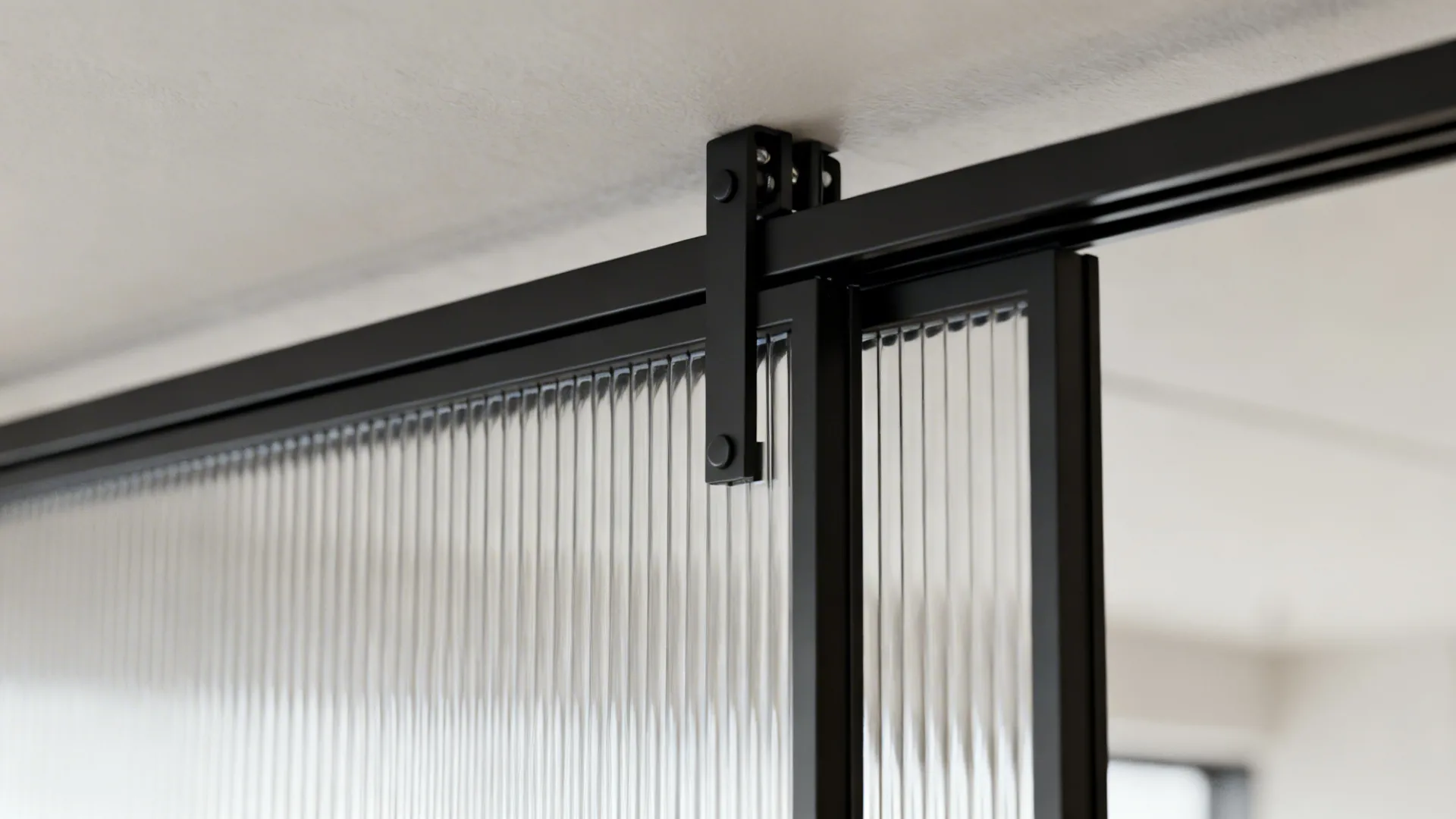 Detail of slim black frame and reeded glass on a sliding kitchen partition.