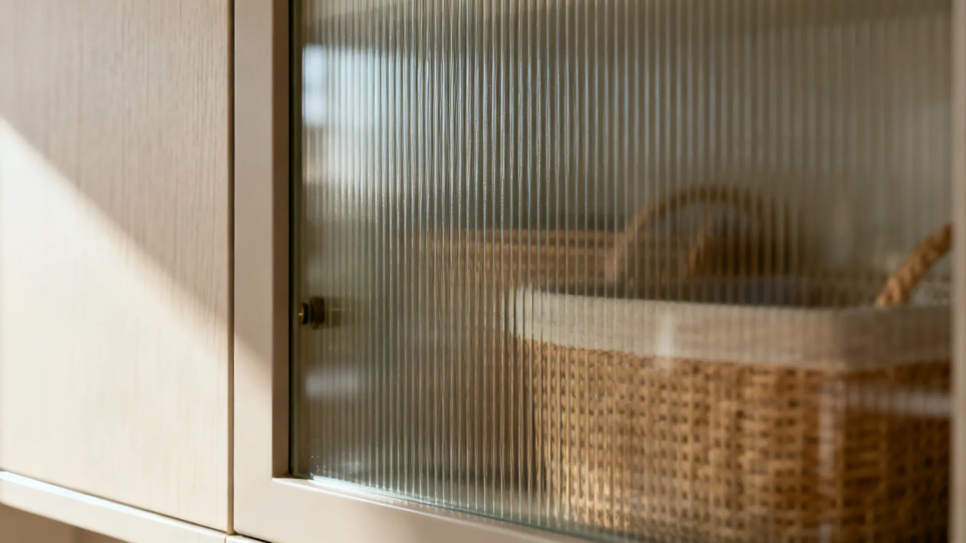 Macro of reeded glass cabinet door with soft reflections and blurred interior baskets.