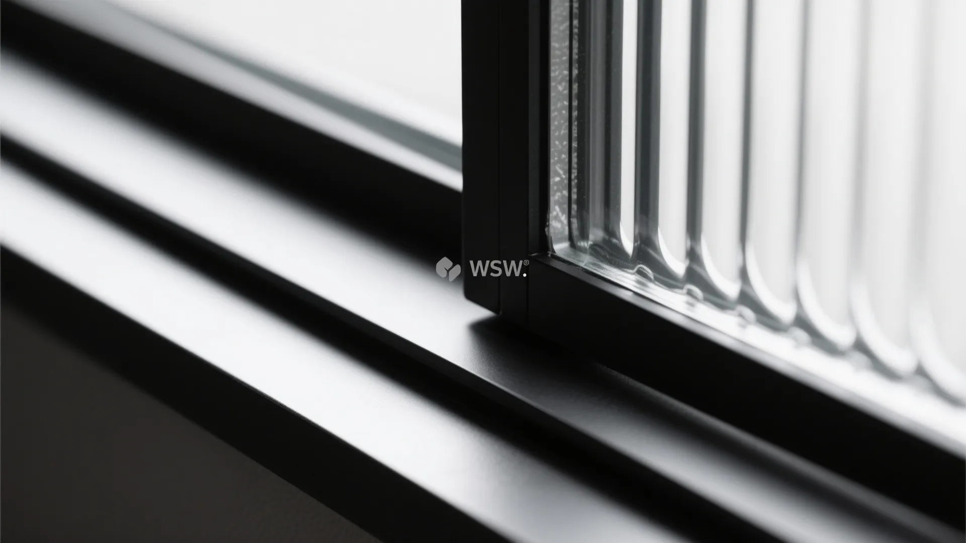 Macro of reeded obscure glass in a slim black frame with clean track detail.