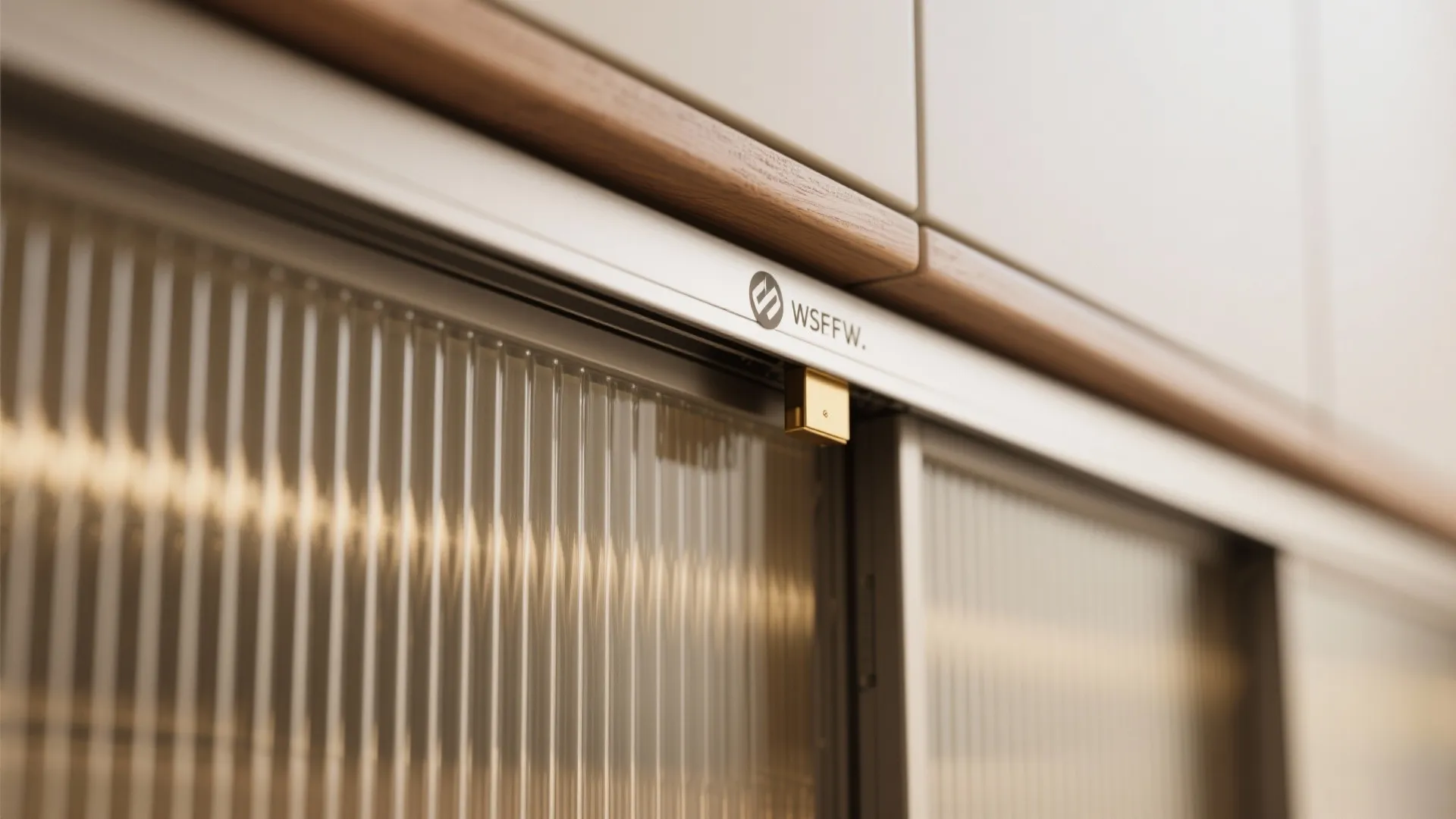 Close-up of reeded glass sliding panel with soft-close track and brass pull, glowing with warm light.