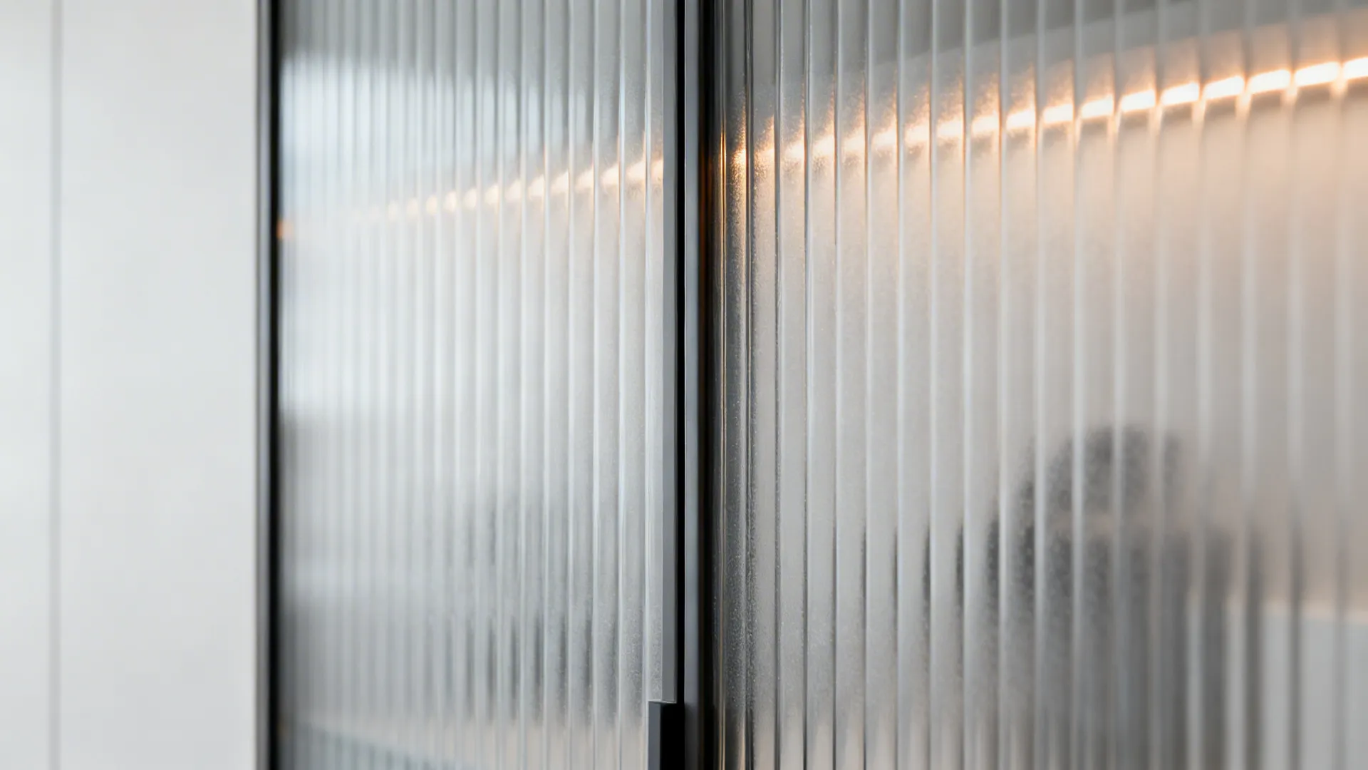 Close-up of vertical reeded frosted glass catching gentle side light.