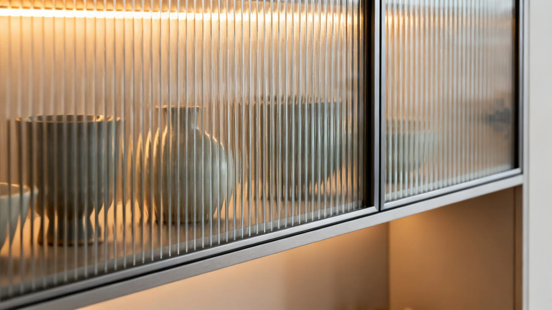 Macro of reeded glass loft door with slim aluminum frame and warm LED glow.