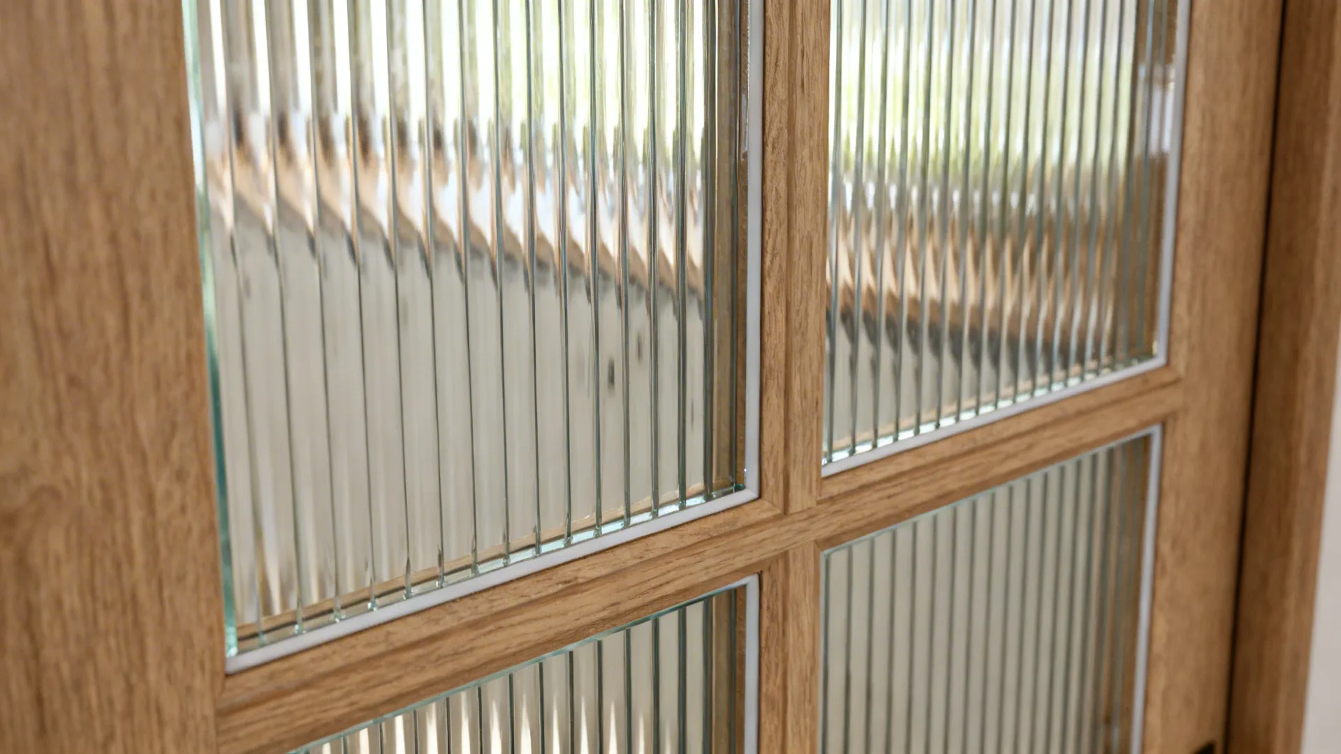 Macro of reeded glass panel in a wooden door showing fluted texture and clarity.
