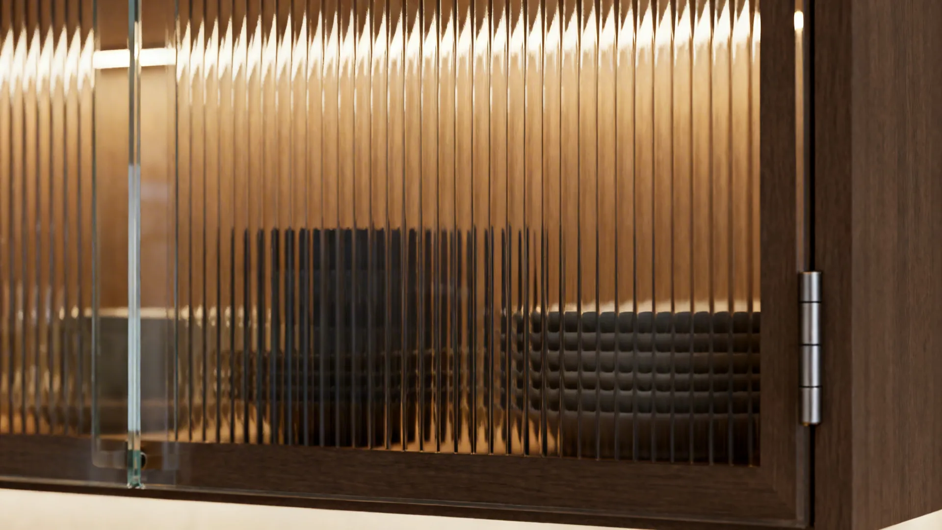 Macro of reeded glass door with warm LED glow and softly blurred dishes behind the texture.