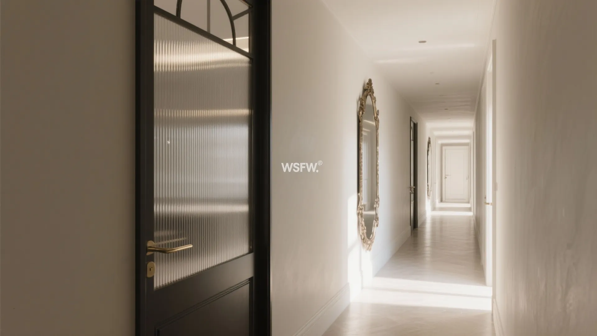 Long bright hallway featuring a black framed glass door and a decorative gold mirror on wall