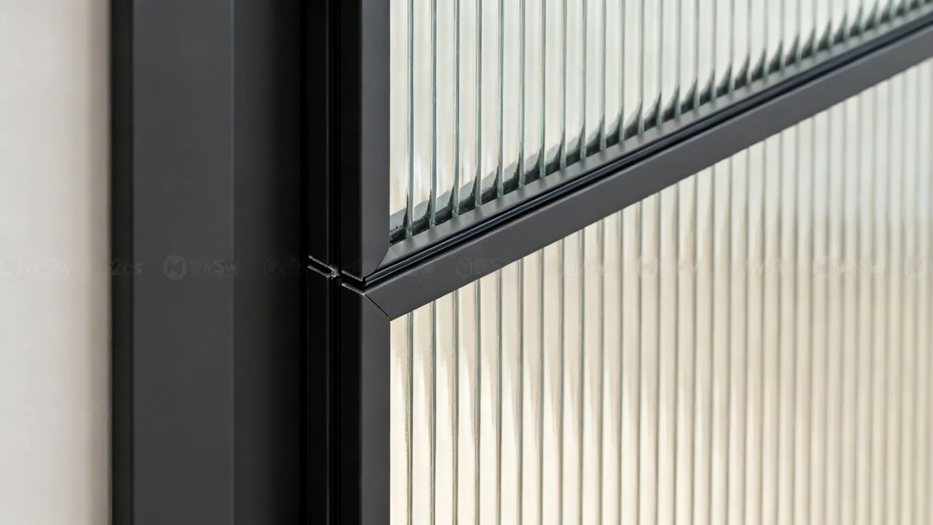 Macro of slim aluminium door profile with reeded glass showing powder-coated finish and fine detail.