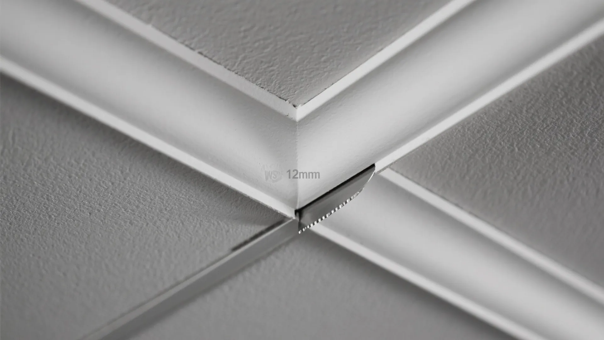 Detailed view showing a twelve millimeter gap between white ceiling panels for modern interior design finish