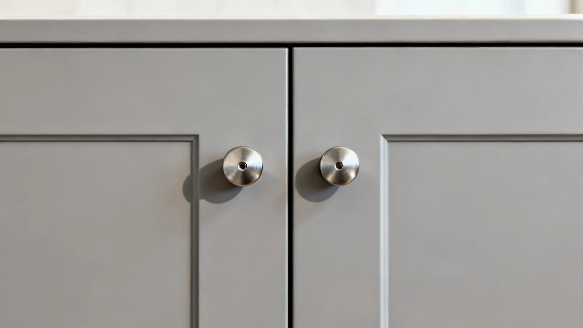 Macro of cabinet fronts with even 2–3 mm reveals and aligned stainless handle drilling.