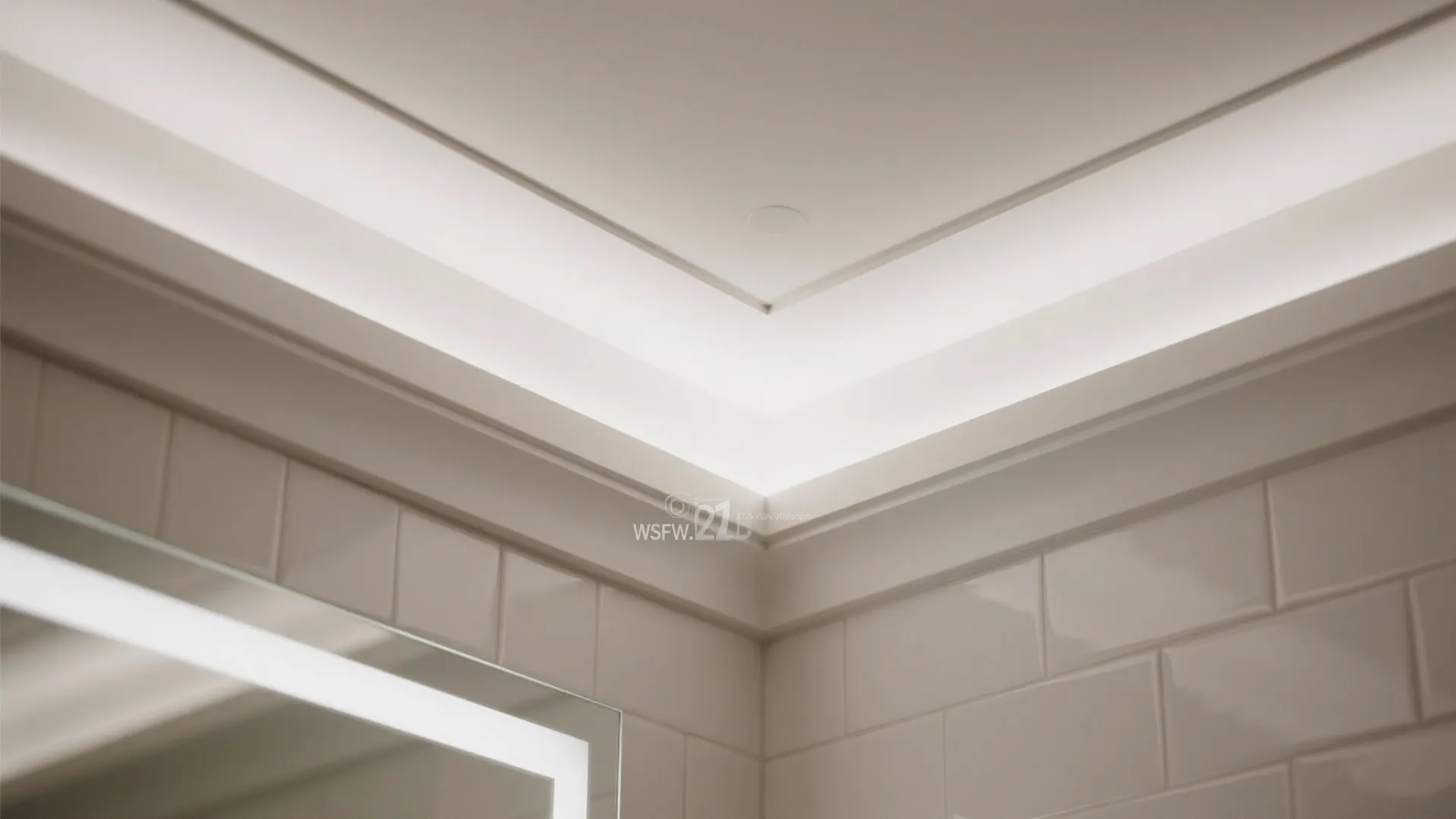 Close up of bathroom ceiling light hidden behind a wall panel with white square tiles