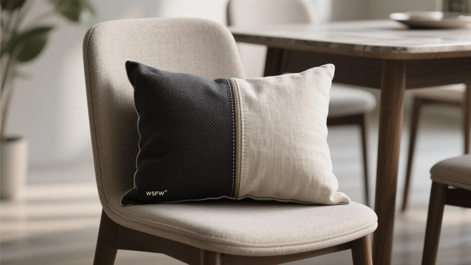 Modern dining chair with two-tone black and beige pillow cover sitting in a bright room