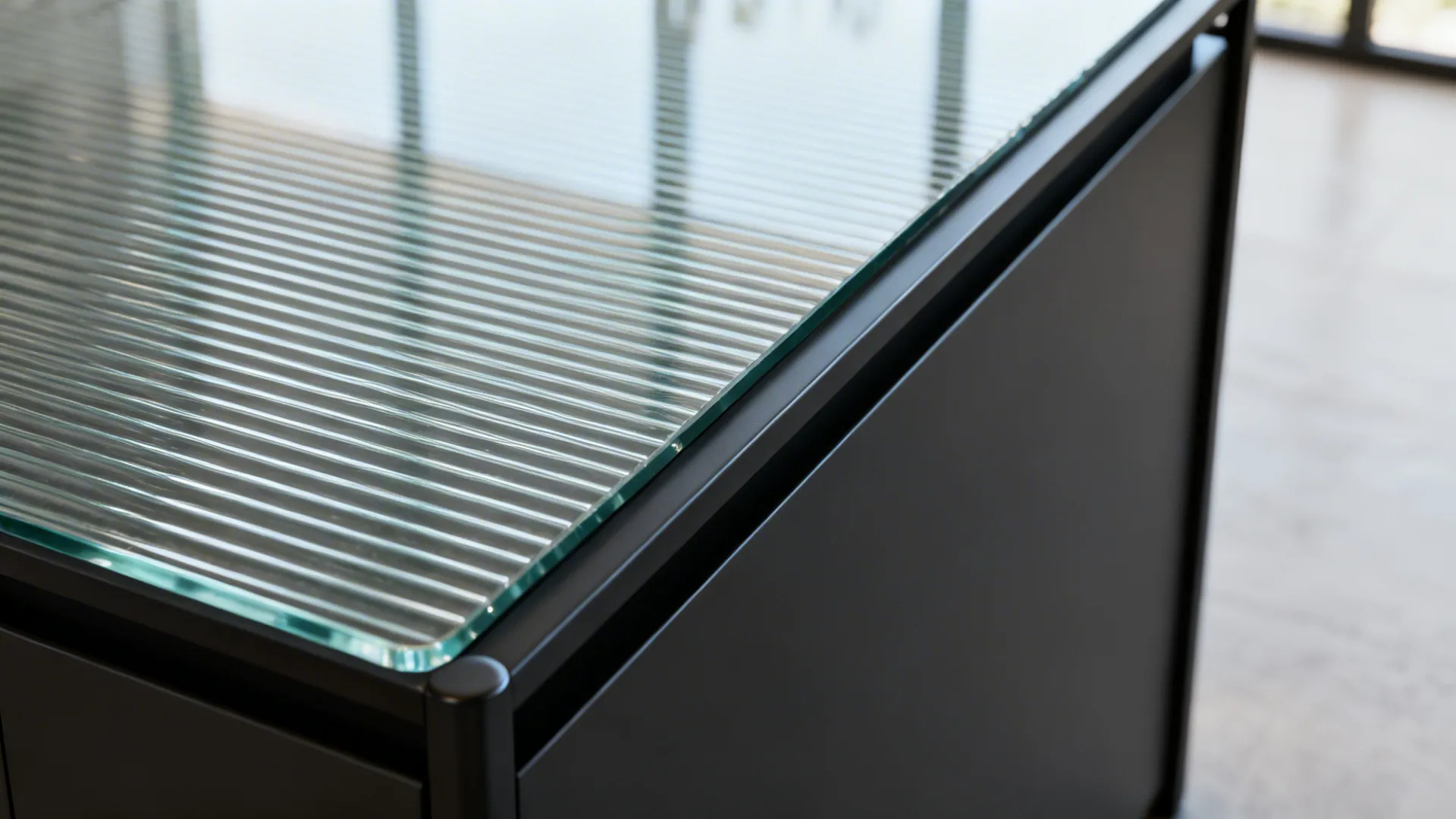 Macro of ribbed glass panel joined to a slim black metal island frame.