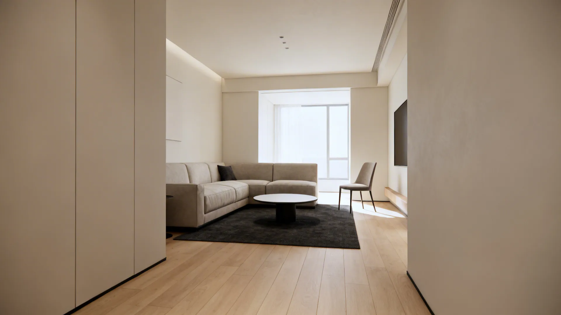 Compact sofa, slim chair, and round table create a breathable small living room layout.