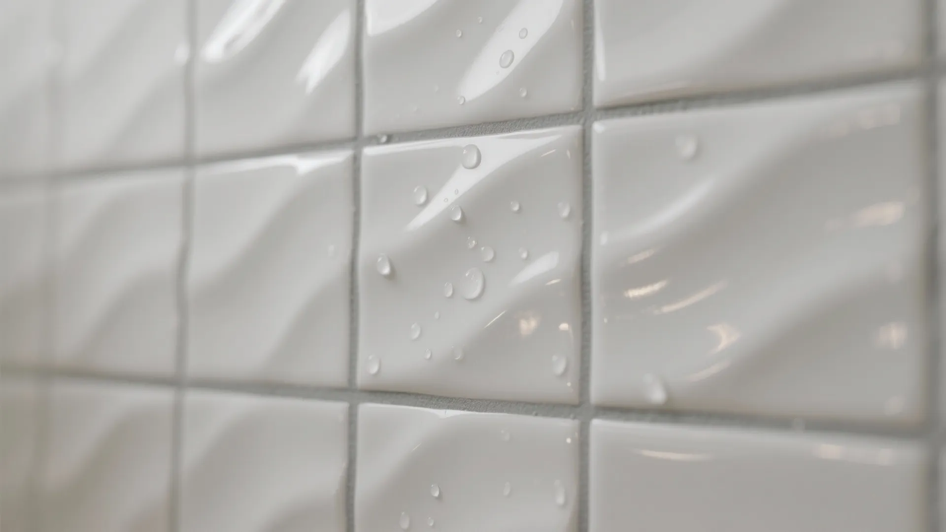 Close up of white wave textured wall tiles with water droplets in a modern bathroom