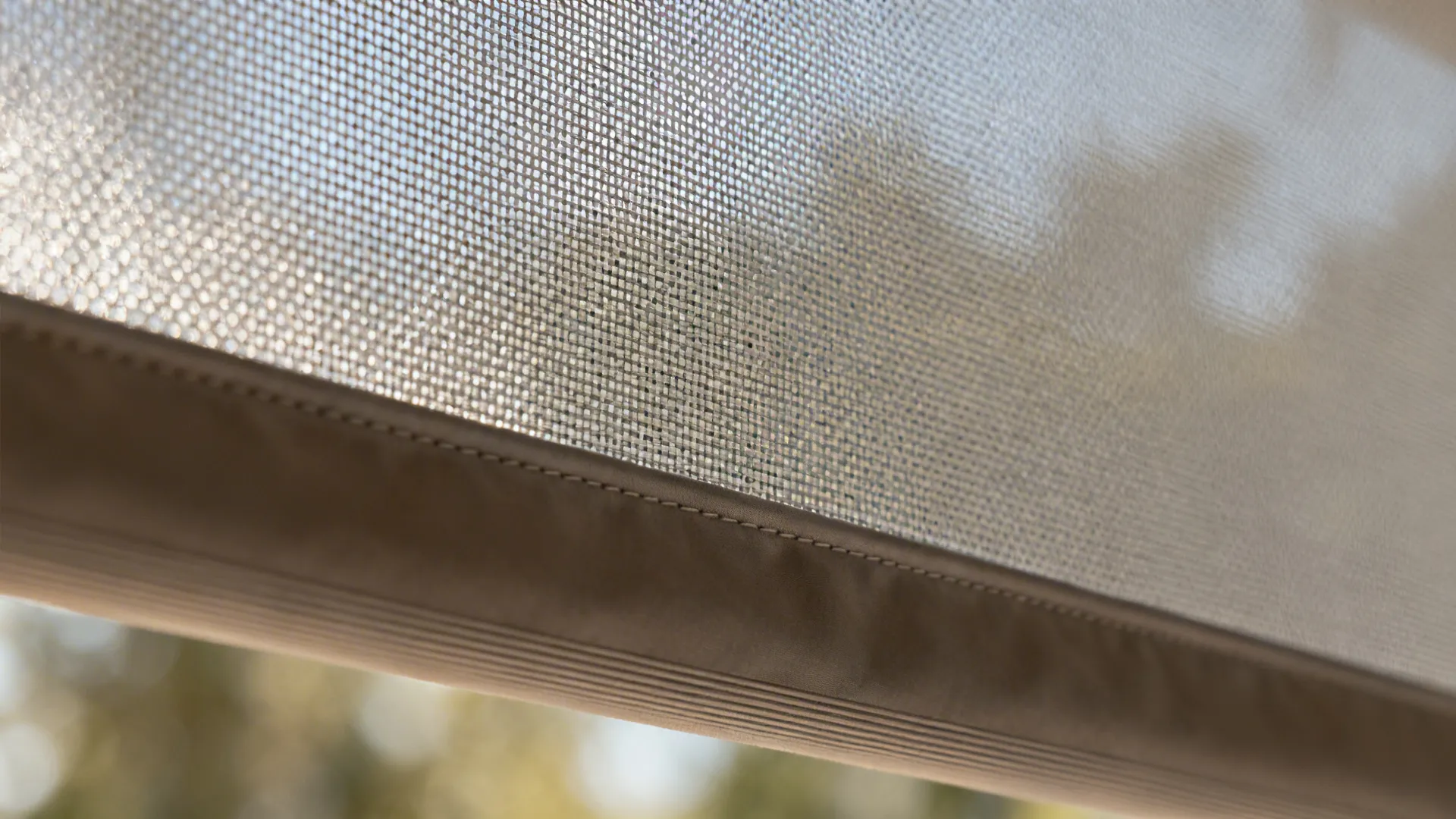 Close-up of warm gray solar roller fabric with 3% openness and fabric-wrapped fascia.
