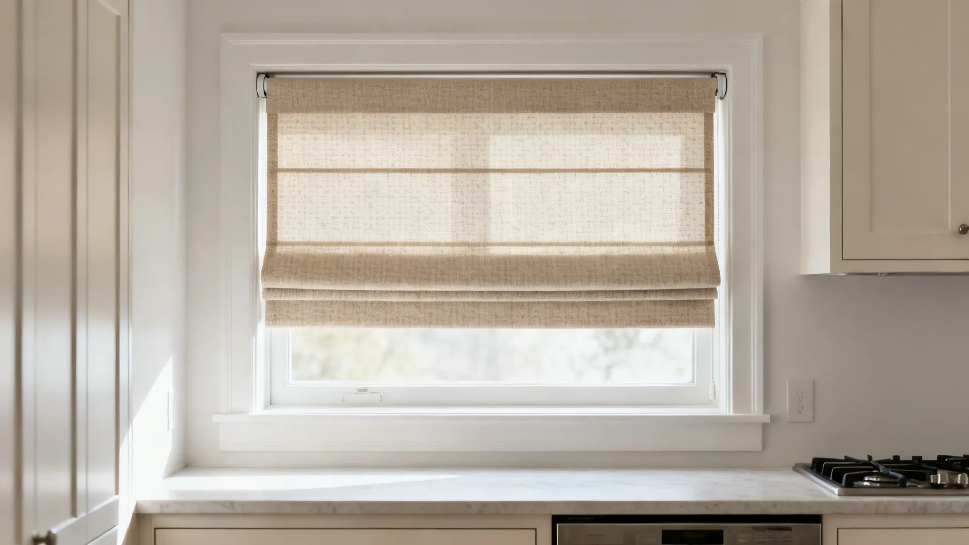 Small kitchen window with a neutral performance-fabric flat Roman shade.