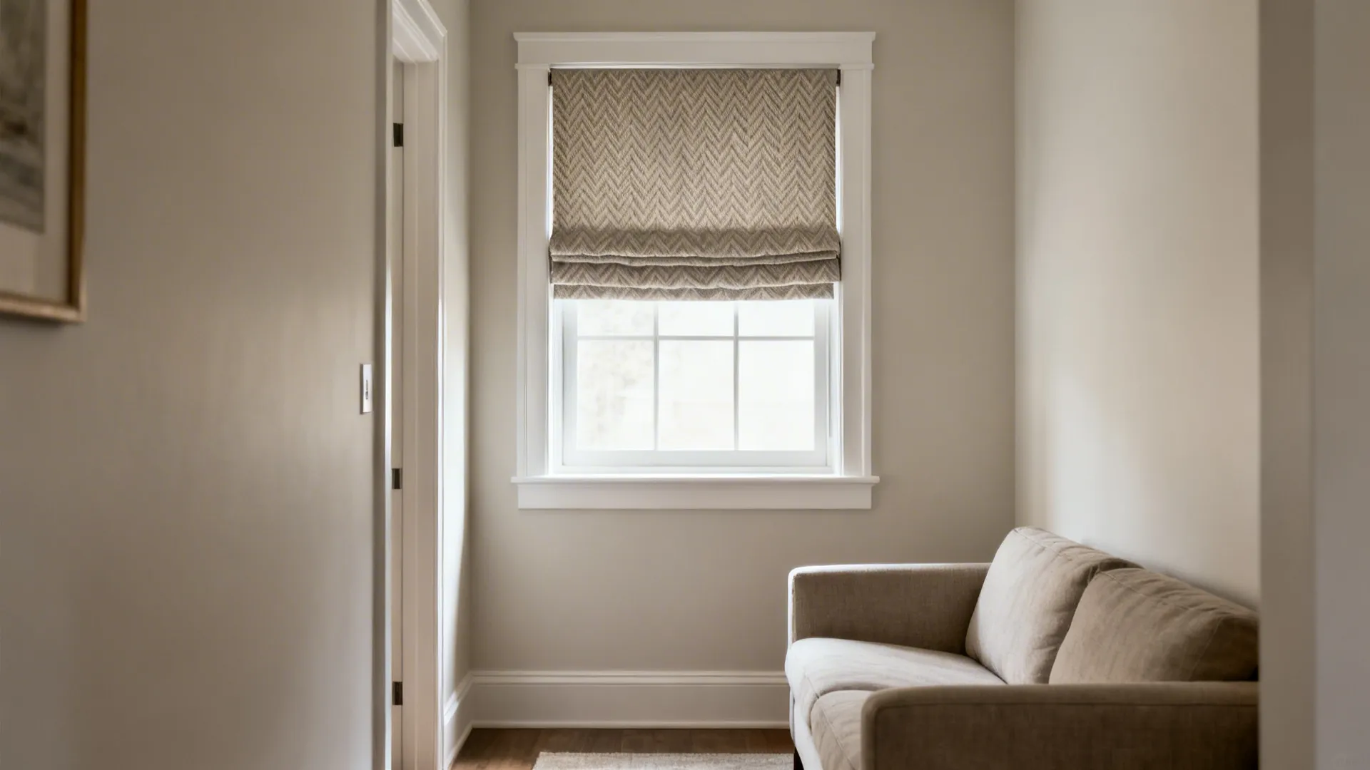 Small living room with relaxed Roman shade in subtle herringbone within the window trim.