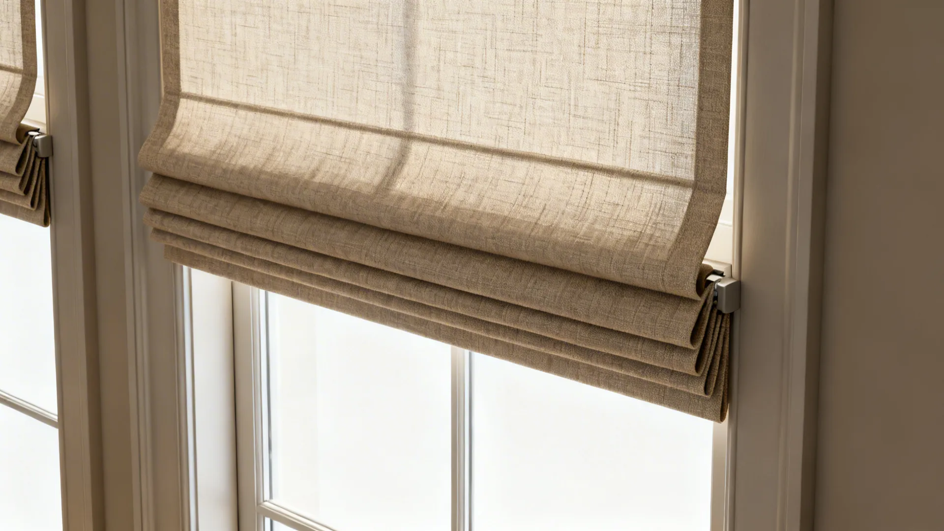 Tailored Roman shades in textured fabric on a floor-to-ceiling window with neat folds.
