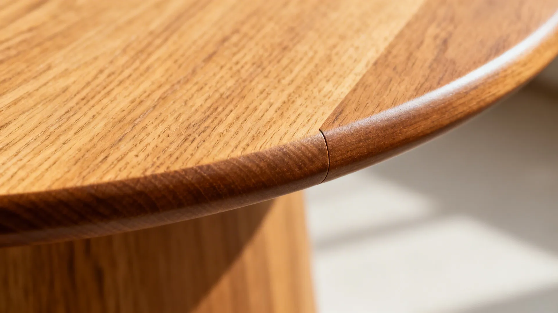 Close-up of a rounded oak tabletop edge with matte topcoat and fine wood grain.