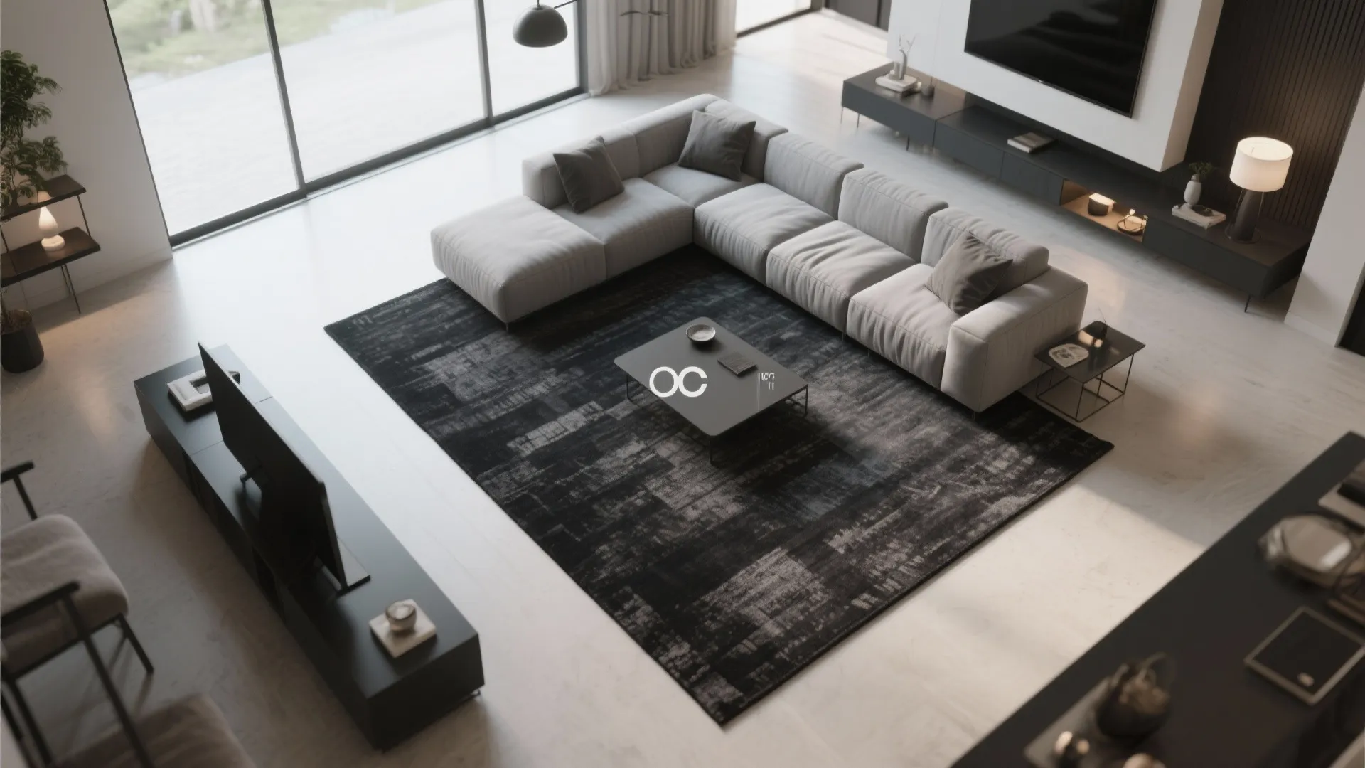 Top view of a modern living room with large grey sofa and dark pattern area rug