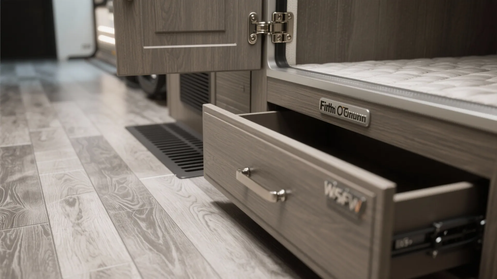 Close up of an open wooden drawer in a bedroom with grey wood pattern floor tiles