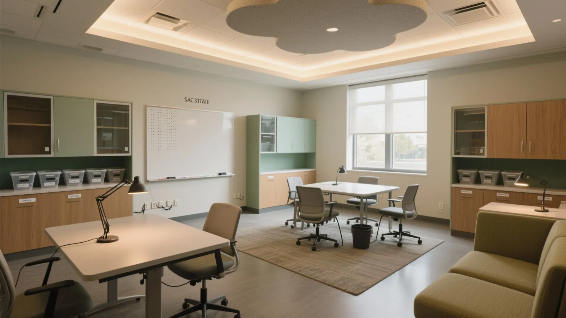 Modern study room with white tables, grey chairs, whiteboard, green cabinets, and flower shaped light