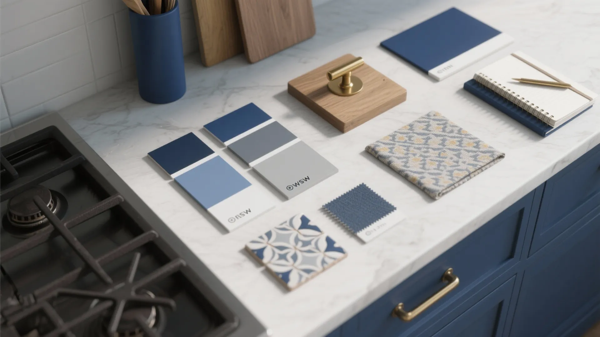 Interior design color samples, fabric swatches, and tiles arranged on a white marble kitchen counter