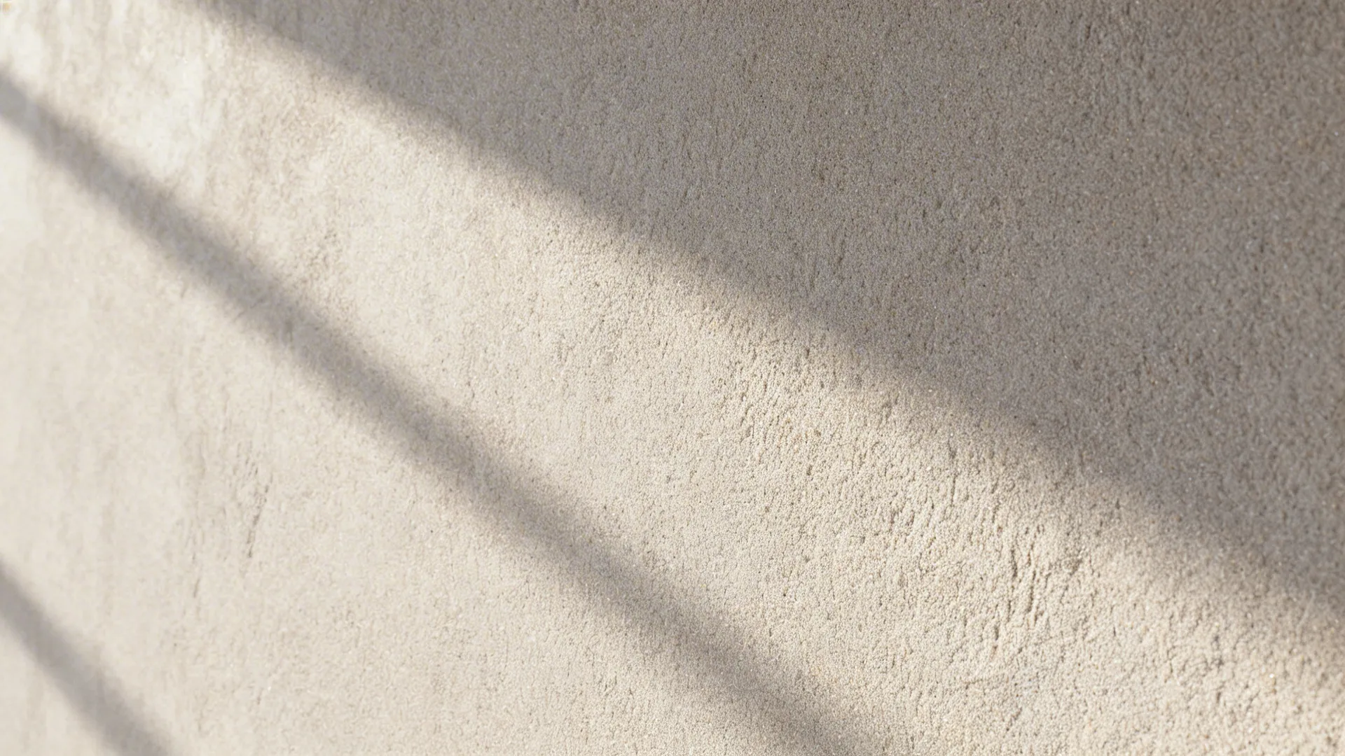 Macro of pale gray sand-infused wall showing fine, even low-relief texture.