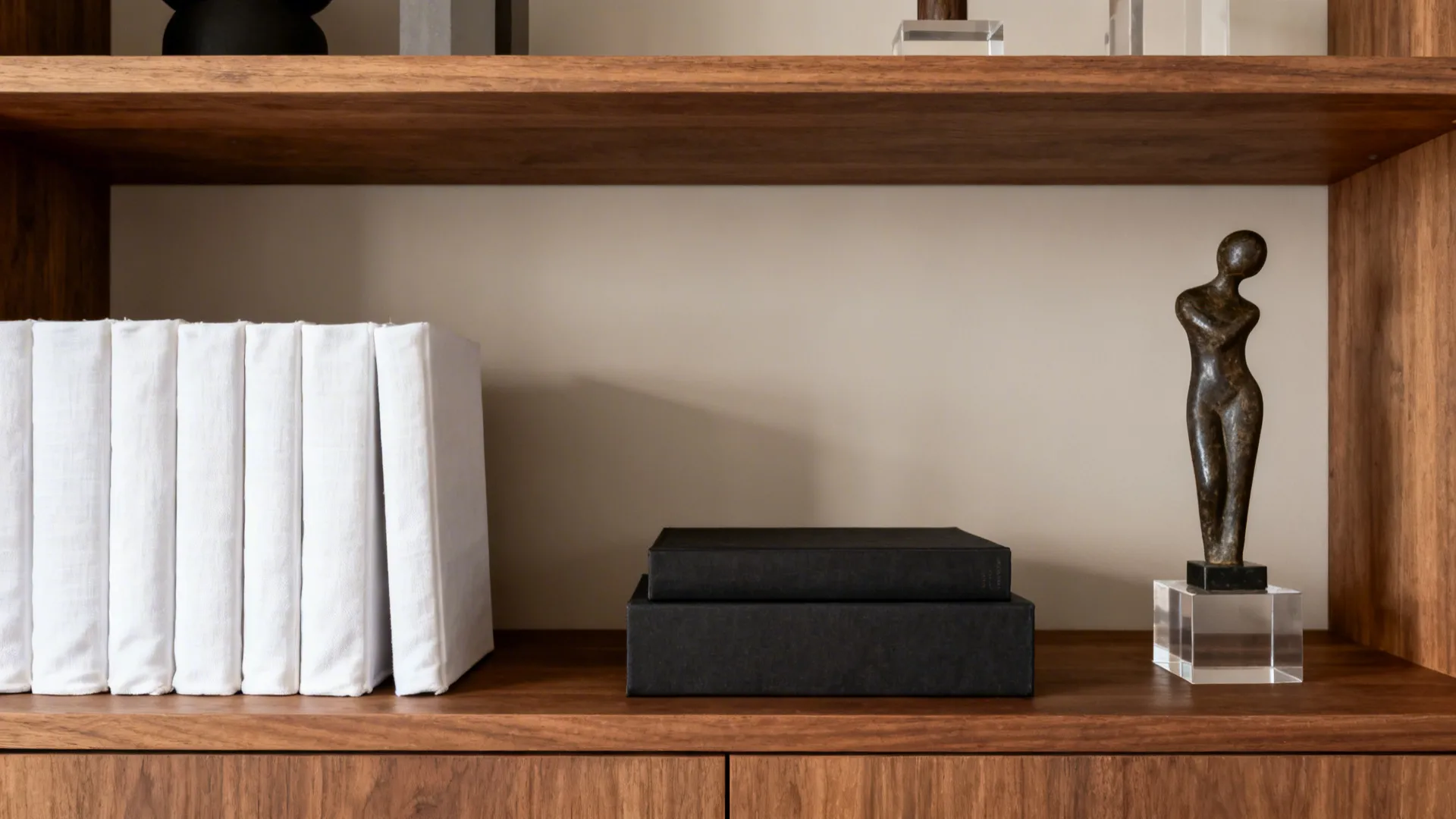 Styled bookcase showing color-blocking and scale balance between light and dark book groupings