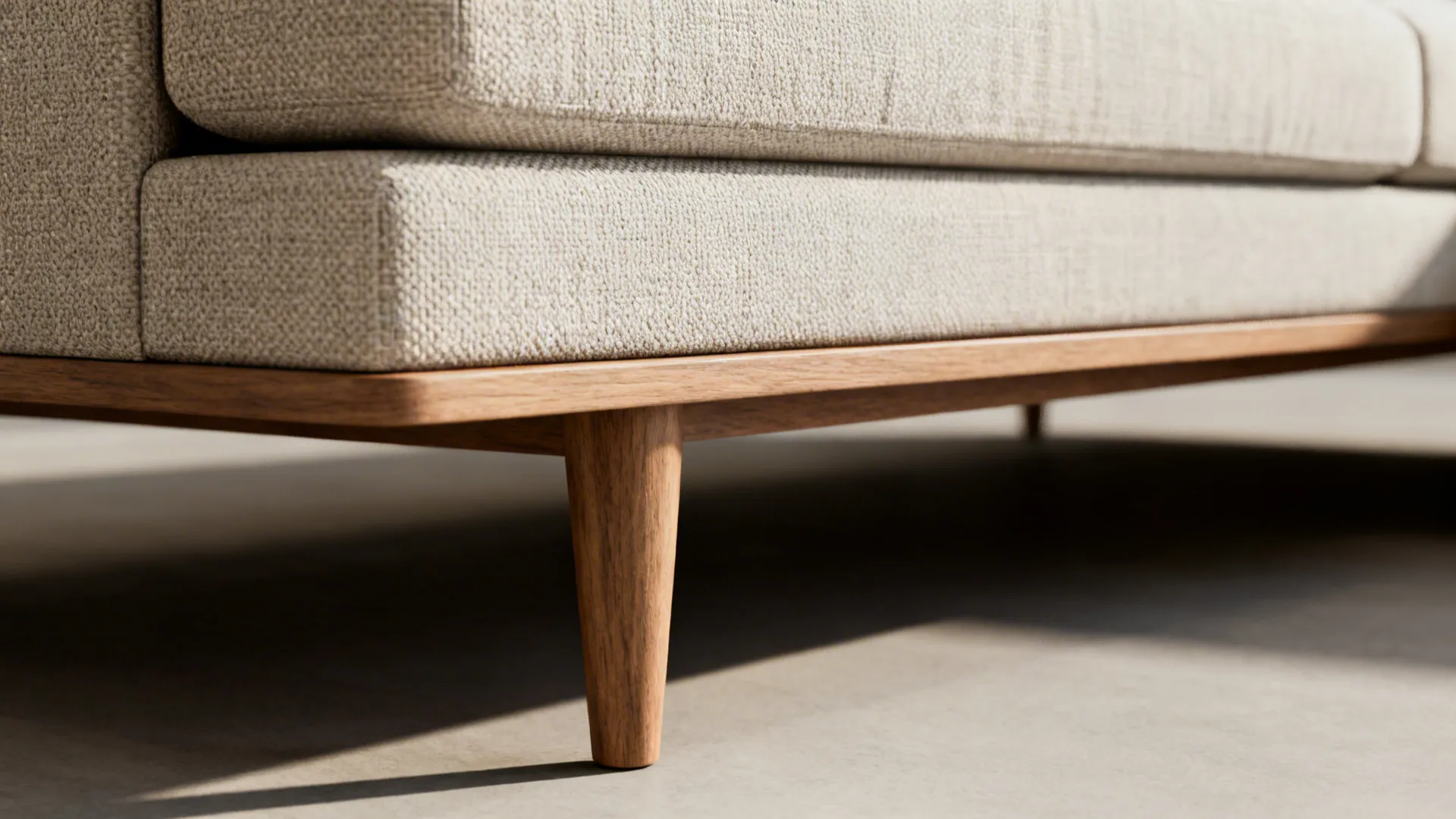Close-up of raised sofa legs and low-profile sectional base showing visual weight differences.