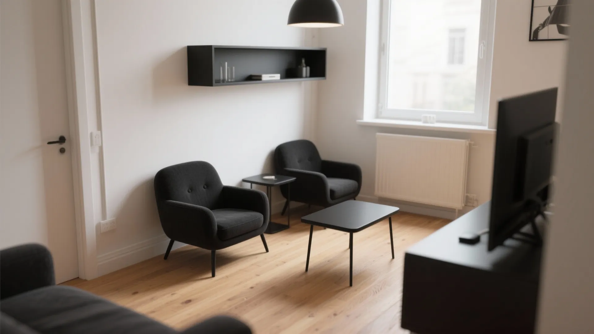Micro-flat living room with two compact black armchairs, slim side table, and open sightlines.