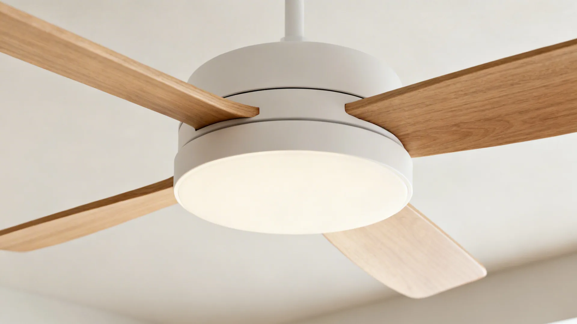 Sleek Scandinavian ceiling fan with thin wooden blades and a soft diffuser in a minimalist interior.