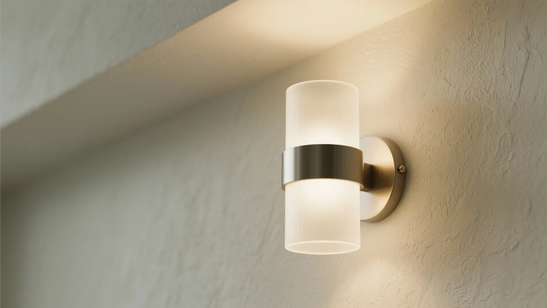 Modern cylinder wall light with metal band providing warm glow on a textured white wall
