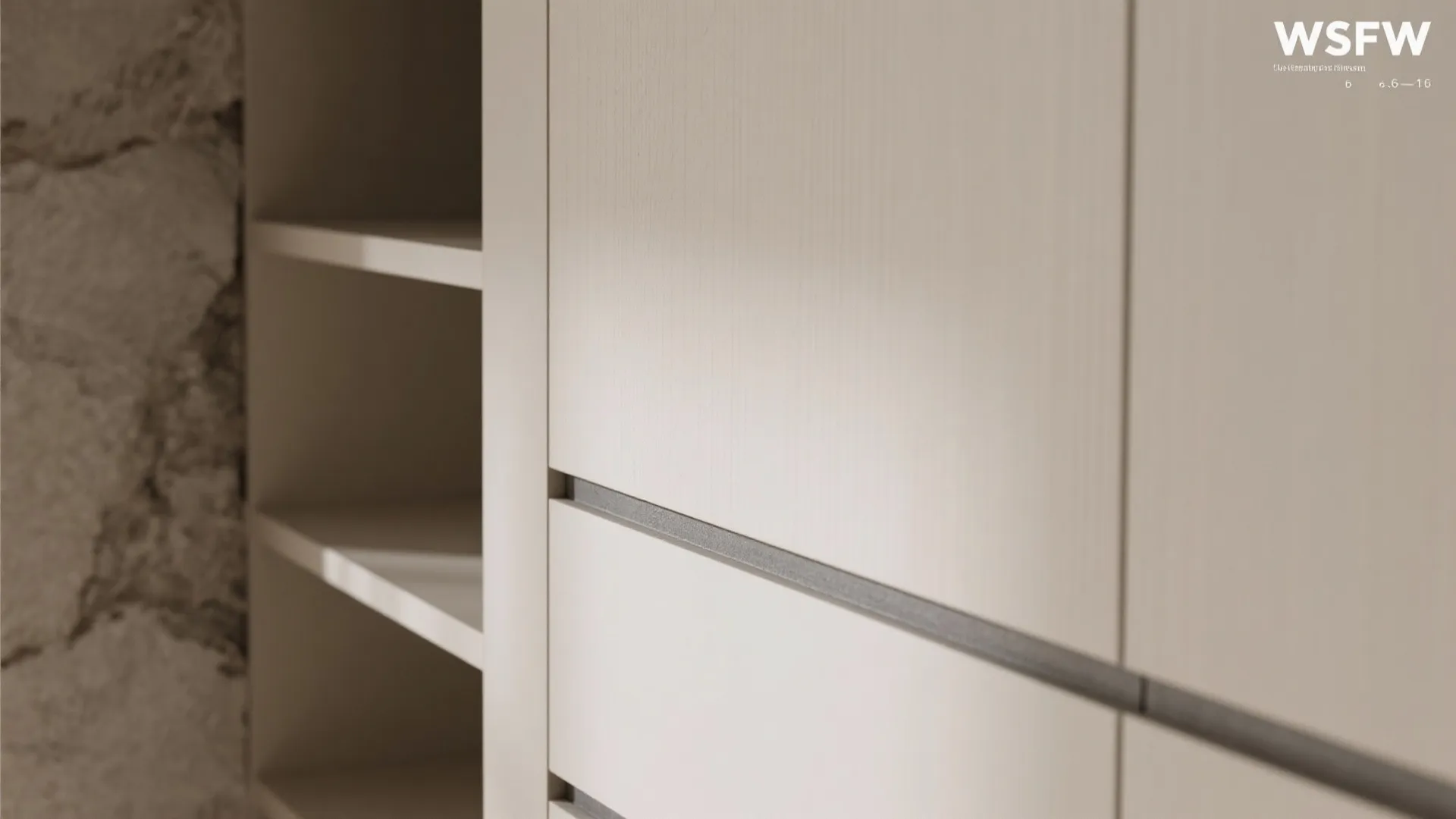 Close up of cream colored storage cabinet with recessed handles next to open display shelves