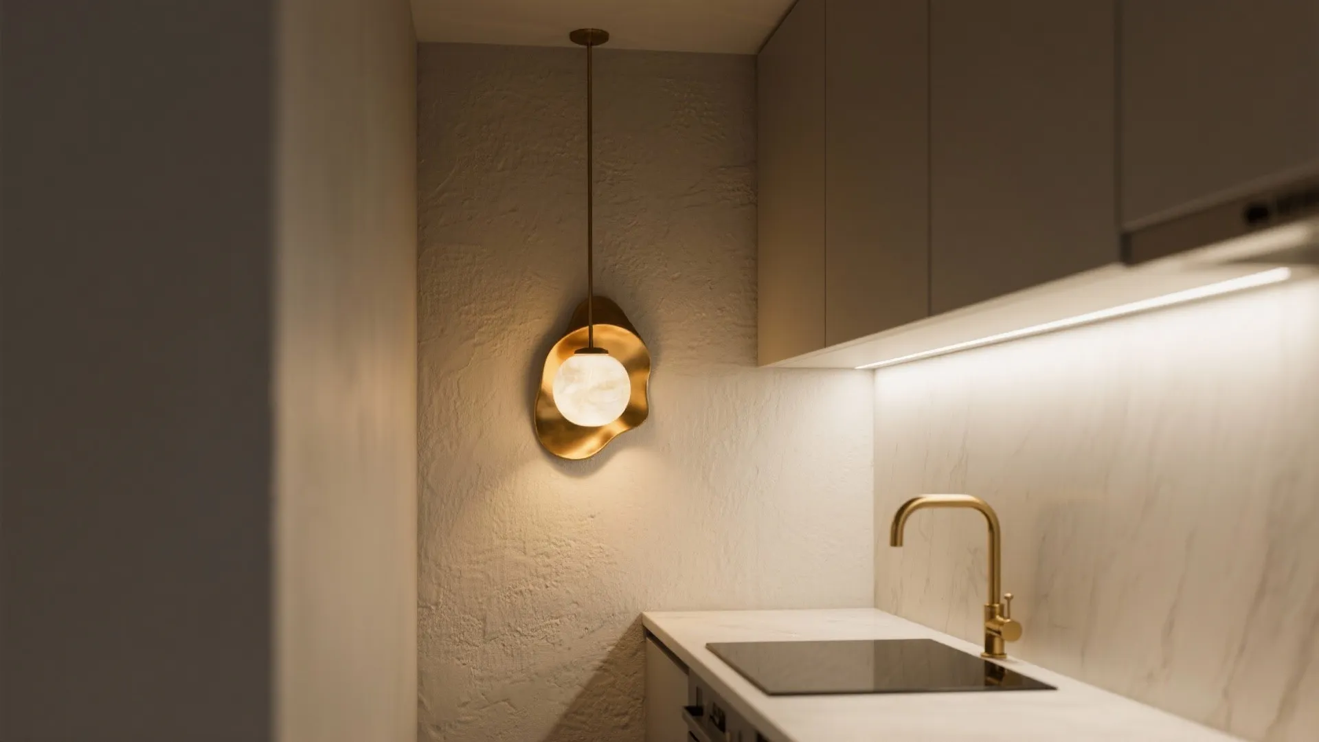 Brass-and-opal sconce in a narrow loft kitchen creating warm layered lighting.