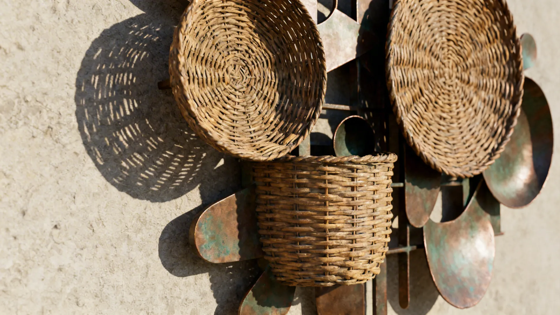 Close-up of woven and metal sculptural wall decor showing texture and shadow.