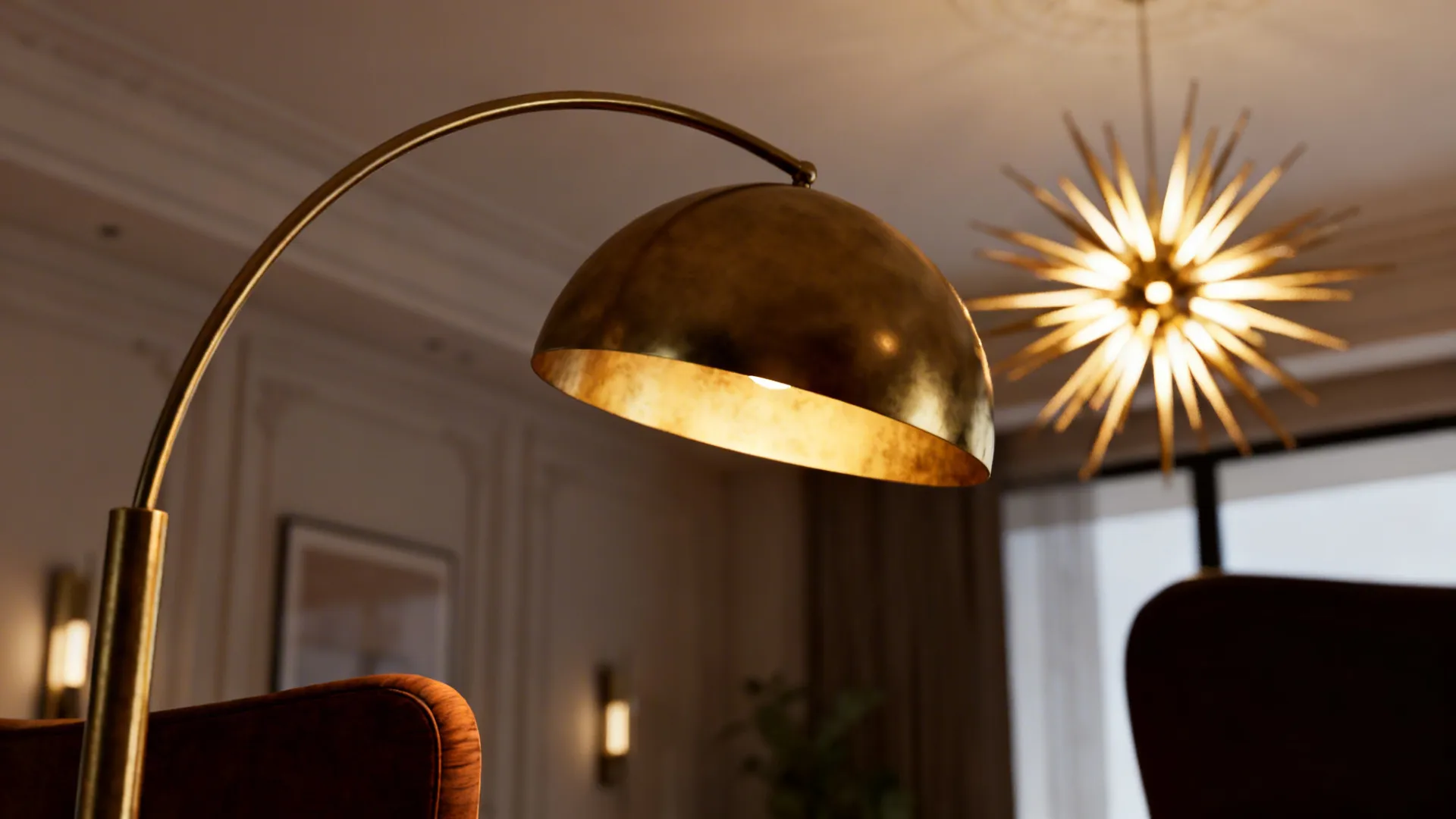 Close-up of an arc floor lamp and starburst chandelier showing sculptural lighting elements in warm brass