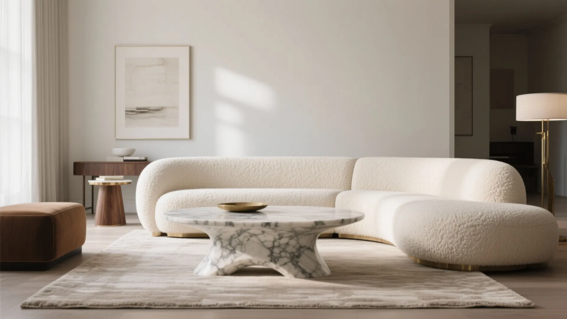 Curved statement sofa with a matching marble coffee table in a bright modern living room.