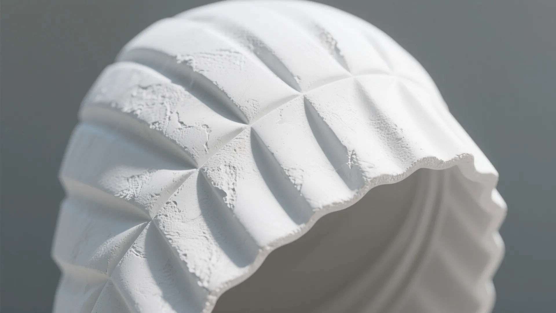 Close up of a white textured kitchen hood with a unique sculptural and artistic pattern