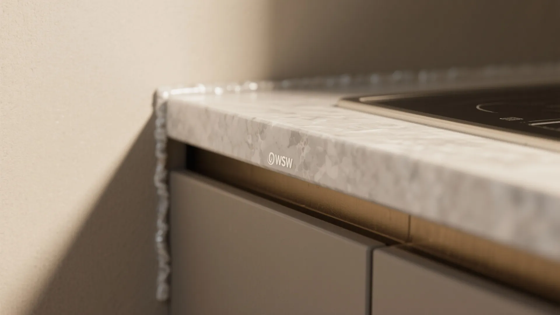 Close up of a marble kitchen counter with a sealed edge next to grey cabinets