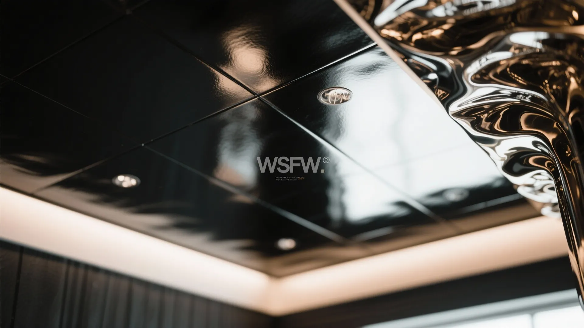 Modern black glossy ceiling design with small round light fixtures and reflective wavy art piece