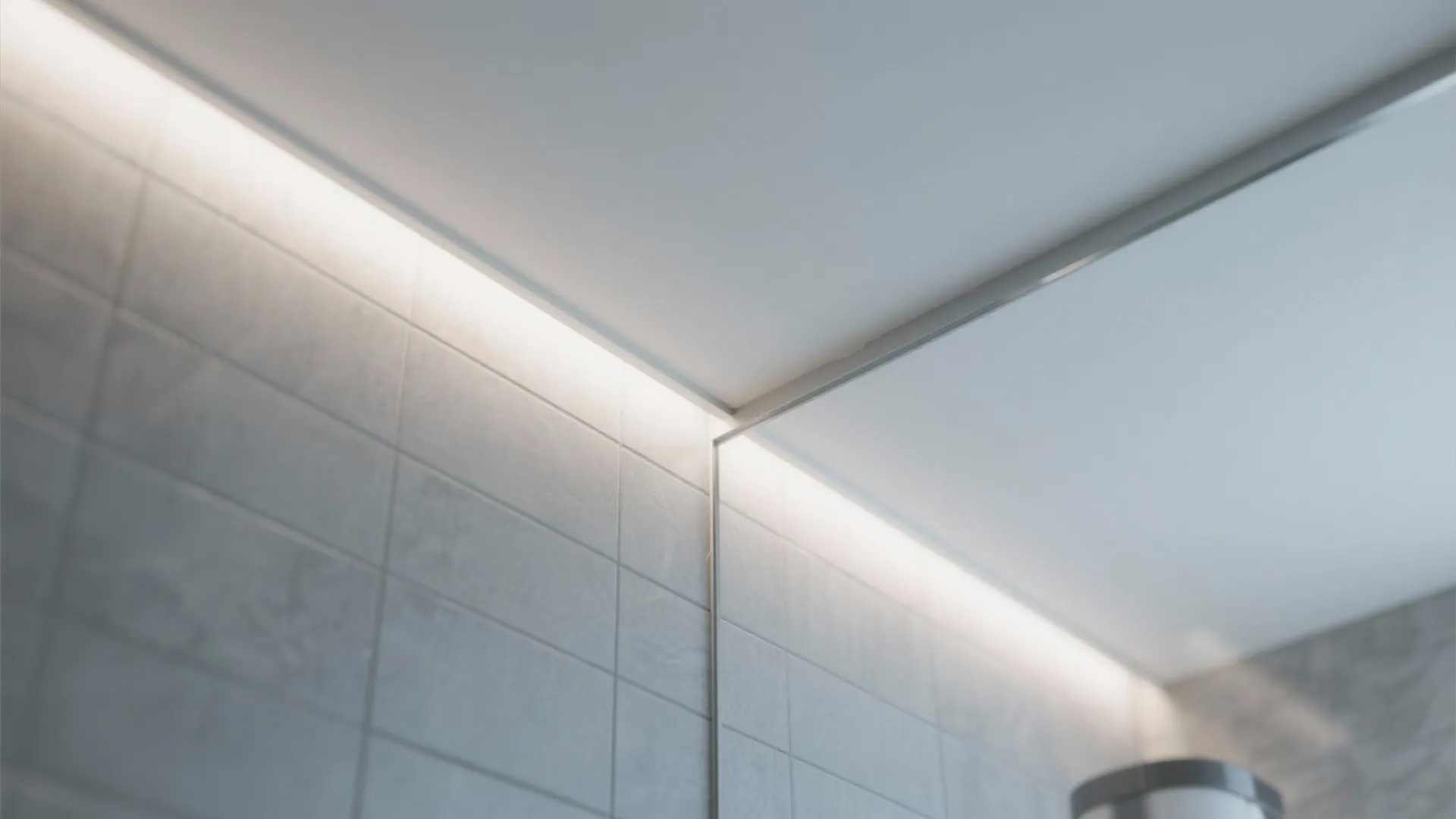 Close-up of a narrow shadow gap reveal between wall and ceiling in a modern bathroom.