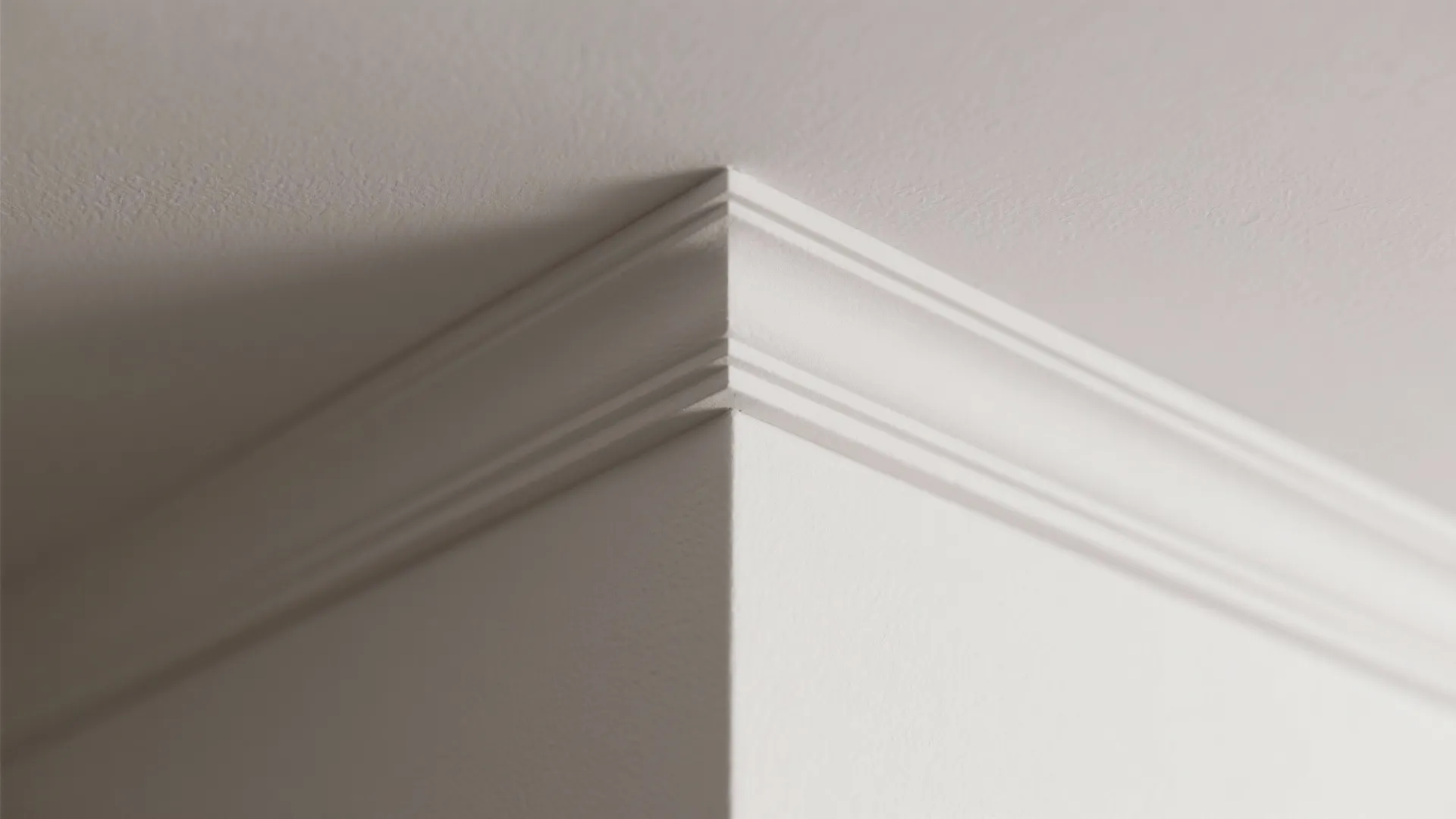 Close up of decorative white wall panel molding installed at the corner of the ceiling