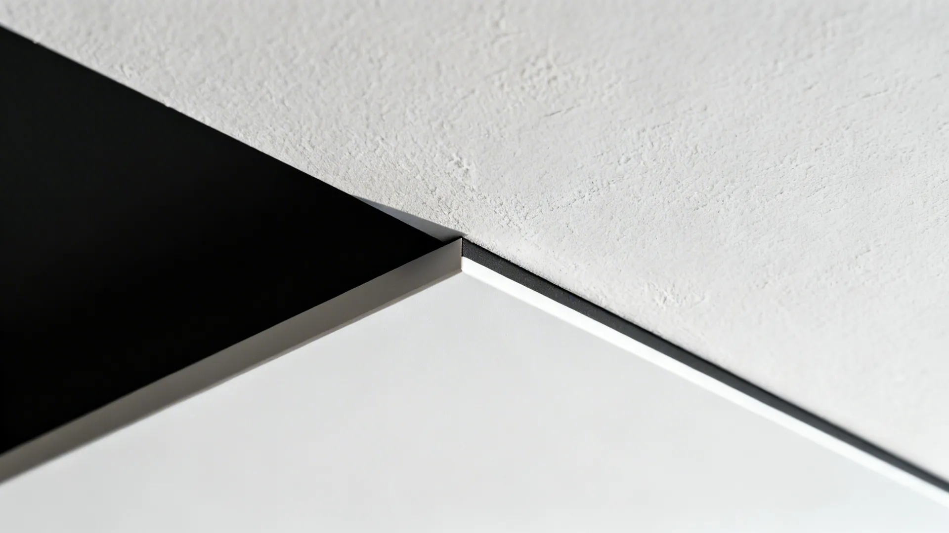 Close-up of a floating ceiling panel showing a uniform matte black shadow gap.