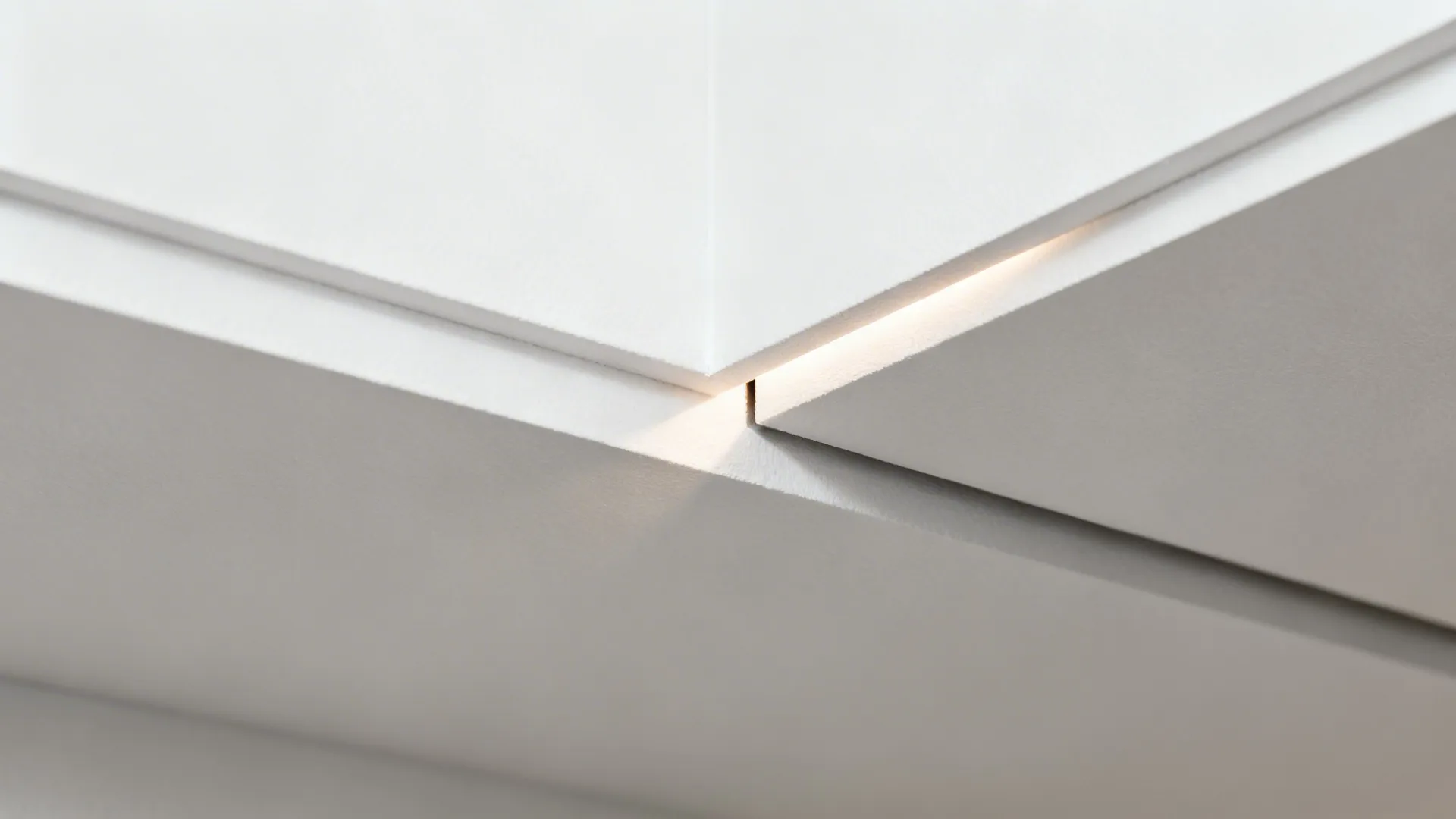 Macro of a precise shadow gap detail around a floating POP ceiling panel.