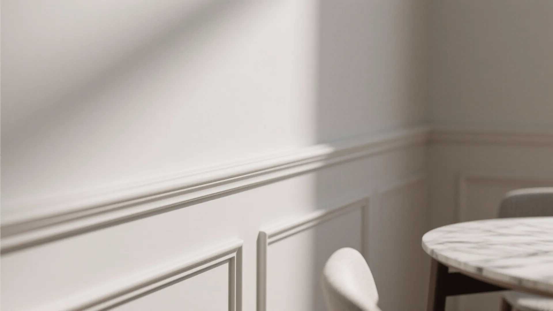 Close up view of white wall panel details with marble table and soft natural shadows