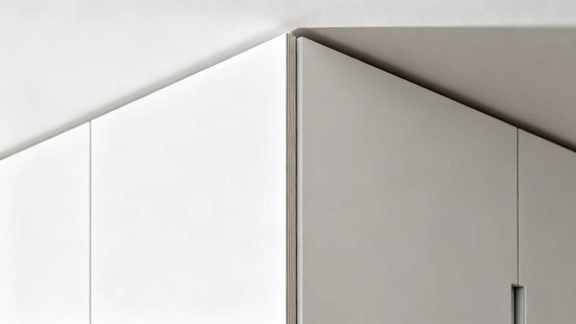Macro of matte white tall cabinet door with clean shadow reveal at ceiling.